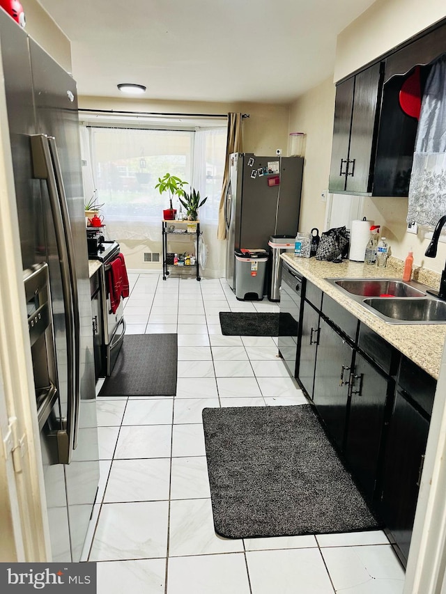 6112 Armor Dr, Clinton, MD 20735 - kitchen featuring a sink, appliances with stainless steel finishes, light countertops, light tile patterned flooring, and dark cabinetry
