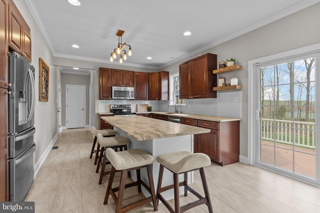 kitchen featuring a kitchen breakfast bar, stainless steel appliances, light countertops, backsplash, and baseboards