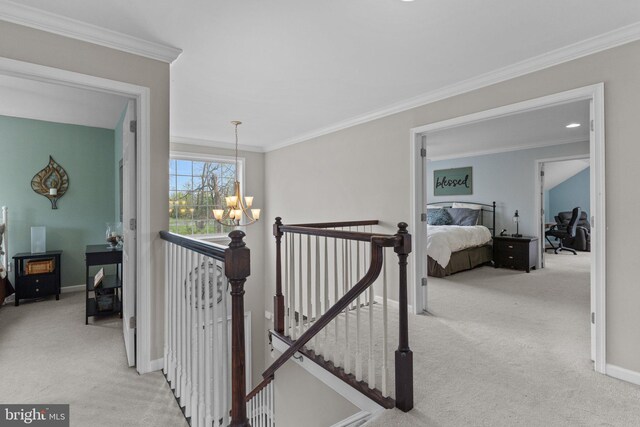 hallway with an upstairs landing, carpet, a chandelier, and ornamental molding