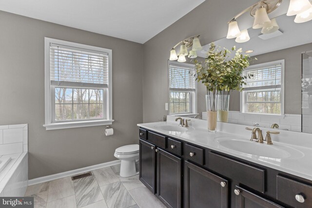 full bath featuring a wealth of natural light, baseboards, and a sink