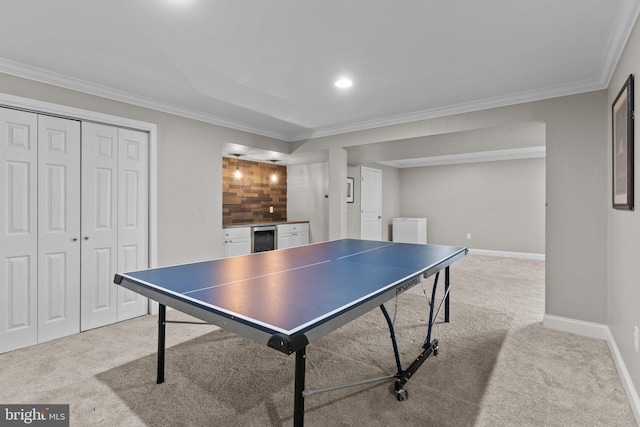 rec room featuring light carpet, crown molding, beverage cooler, and baseboards