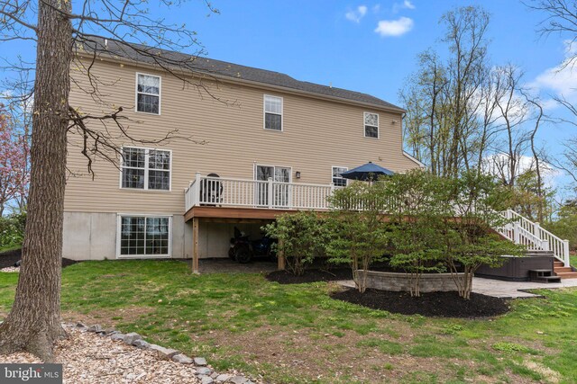back of house featuring a wooden deck, a lawn, and stairway