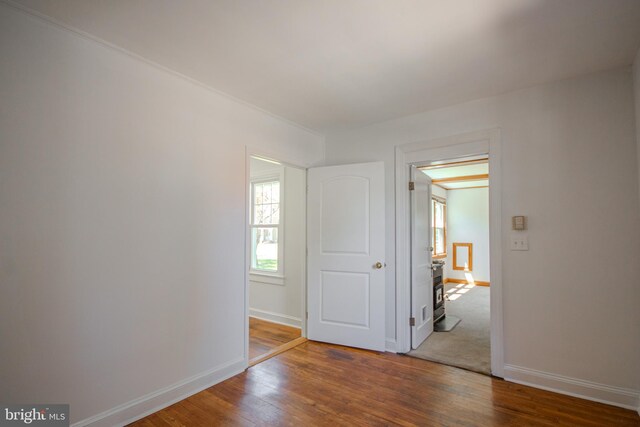 spare room featuring baseboards and wood finished floors
