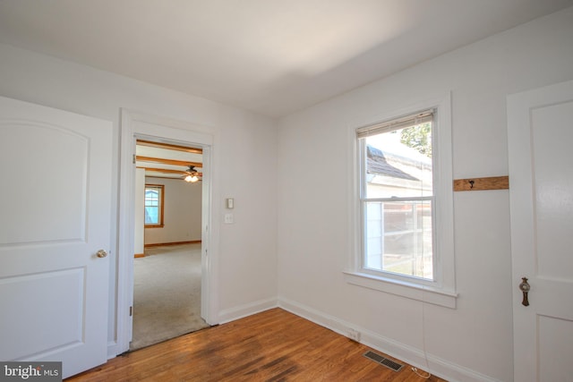unfurnished room with visible vents, baseboards, and wood finished floors