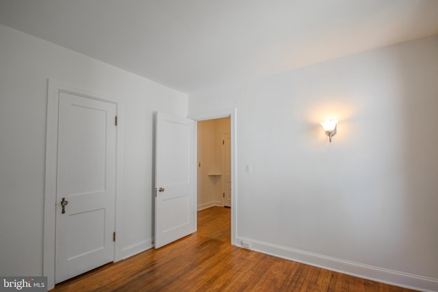 unfurnished bedroom with baseboards and wood finished floors