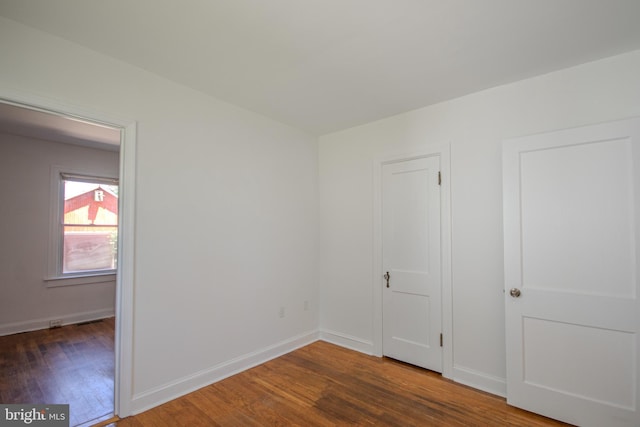 empty room with baseboards and wood finished floors