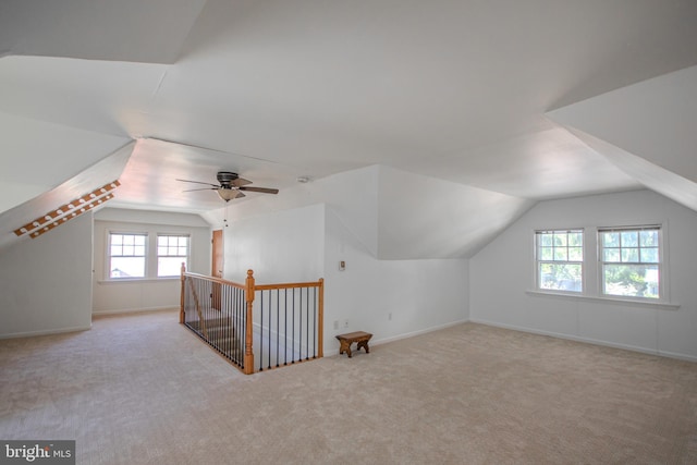 additional living space featuring carpet floors, baseboards, vaulted ceiling, and ceiling fan
