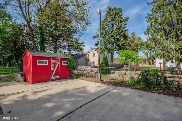 view of patio / terrace with an outbuilding, fence, and a storage shed