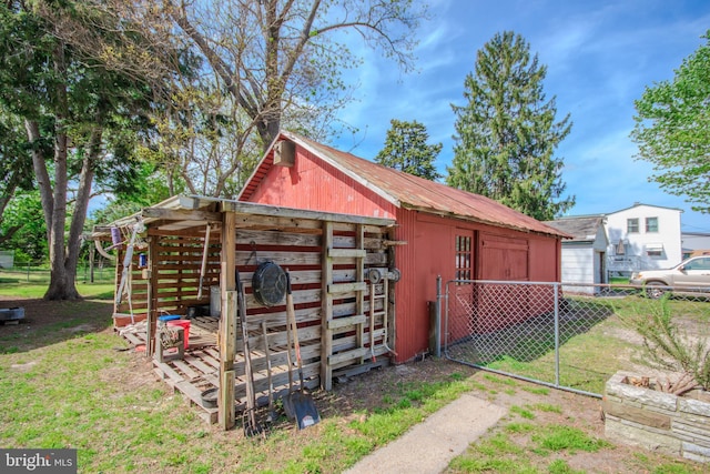 view of outdoor structure featuring fence and an outdoor structure
