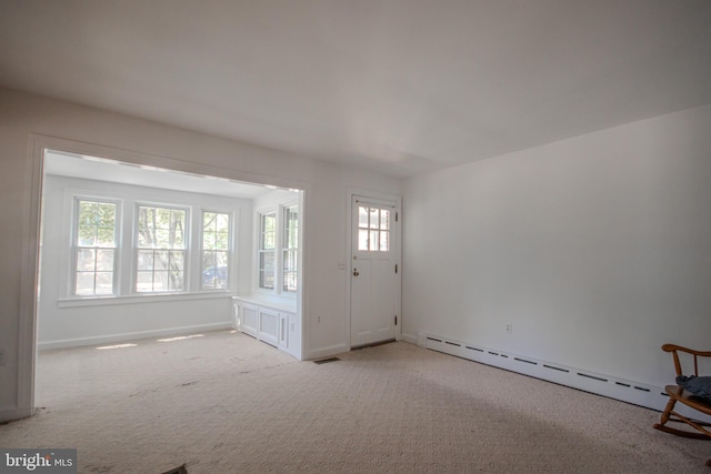 interior space featuring light colored carpet, a wealth of natural light, visible vents, and a baseboard radiator