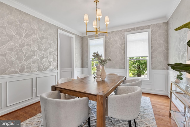 dining room with ornamental molding, wainscoting, wallpapered walls, and a notable chandelier