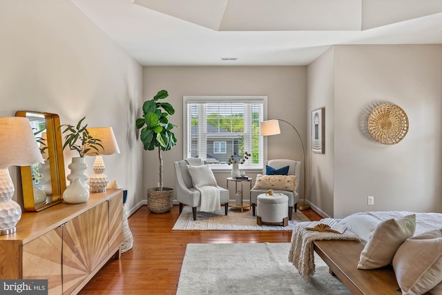 sitting room featuring baseboards, wood finished floors, and visible vents