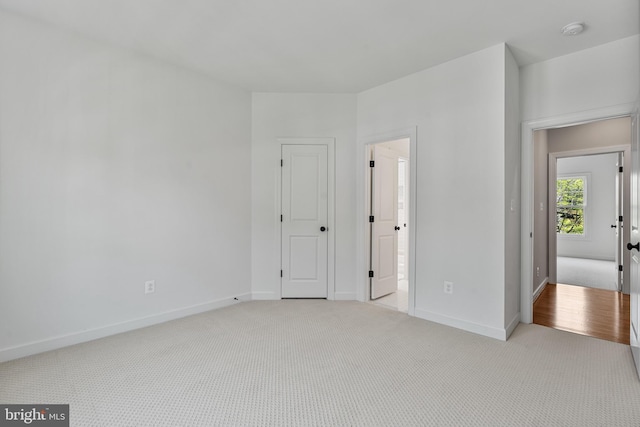 unfurnished bedroom featuring baseboards and light colored carpet