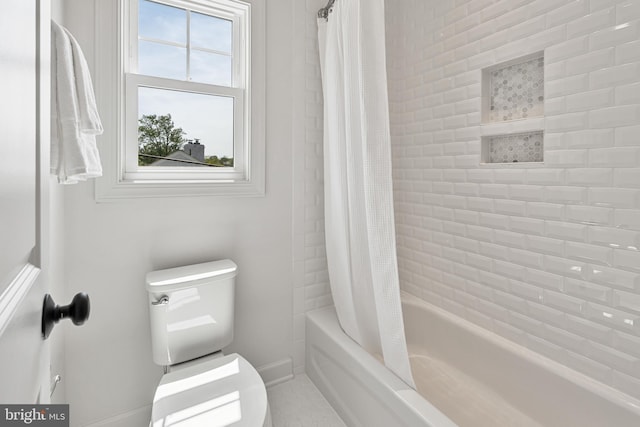 full bath with baseboards, shower / tub combo with curtain, and toilet