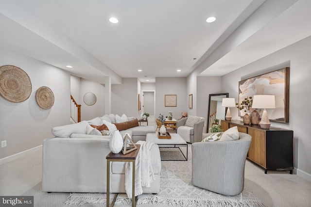 living area featuring recessed lighting, stairs, baseboards, and light carpet