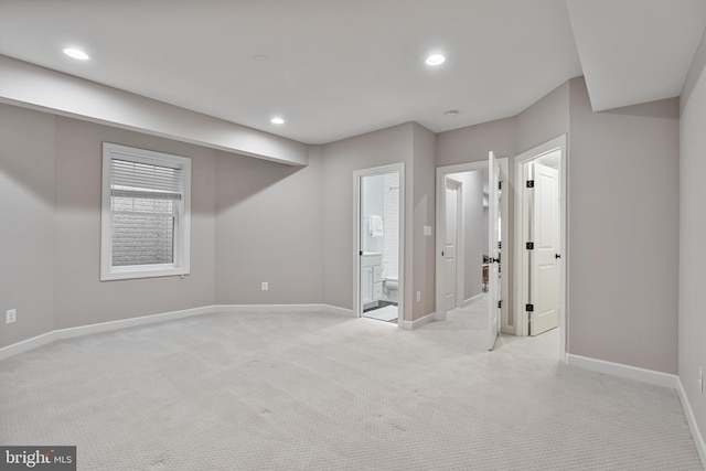interior space with baseboards, light carpet, and recessed lighting