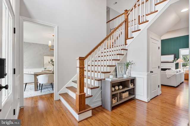 4950 34th St N, Arlington, VA 22207 - stairs featuring a decorative wall, a high ceiling, wainscoting, and wood finished floors