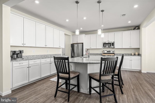 7269 Liberty Ct, Ruther Glen, VA 22546 - kitchen with white cabinetry, stainless steel appliances, visible vents, and dark wood-type flooring