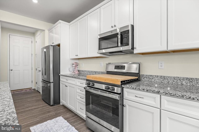 7269 Liberty Ct, Ruther Glen, VA 22546 - kitchen featuring white cabinetry, light stone counters, dark wood finished floors, and appliances with stainless steel finishes