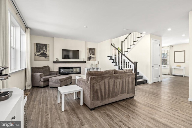 7269 Liberty Ct, Ruther Glen, VA 22546 - living area featuring stairs, a healthy amount of sunlight, a glass covered fireplace, and wood finished floors
