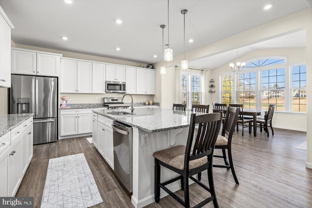 7269 Liberty Ct, Ruther Glen, VA 22546 - kitchen with a breakfast bar area, dark wood finished floors, an inviting chandelier, a sink, and appliances with stainless steel finishes