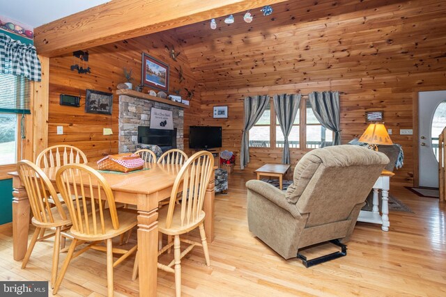 134 Highland Ave, Accident, MD 21520 - dining space featuring high vaulted ceiling, light wood-style flooring, a healthy amount of sunlight, and wooden walls