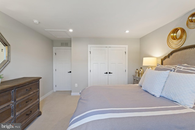bedroom featuring a closet, attic access, light carpet, baseboards, and visible vents