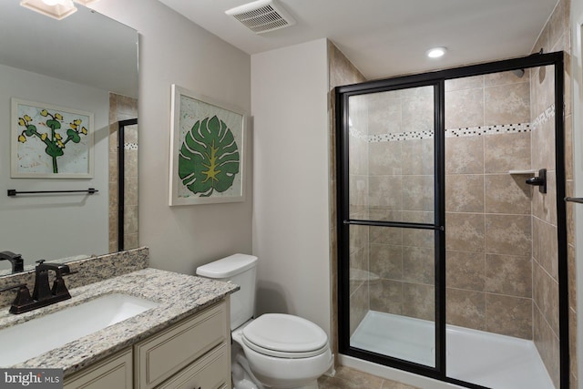 full bath featuring vanity, visible vents, a shower stall, and toilet