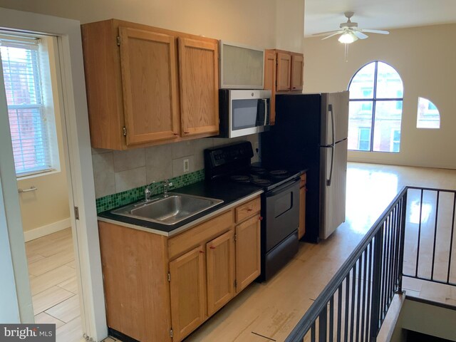 1921 W Diamond St, Philadelphia, PA 19121 - kitchen featuring a sink, black range with electric stovetop, tasteful backsplash, stainless steel microwave, and ceiling fan