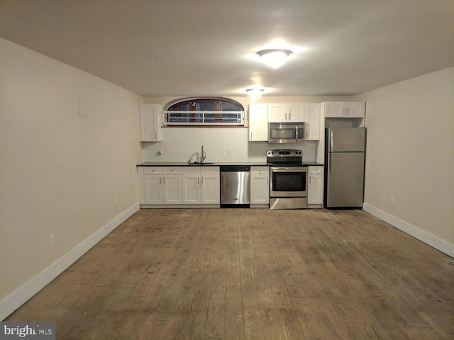 1921 W Diamond St, Philadelphia, PA 19121 - kitchen featuring white cabinets, a sink, wood finished floors, and appliances with stainless steel finishes