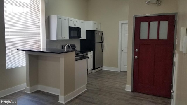 1921 W Diamond St, Philadelphia, PA 19121 - kitchen with appliances with stainless steel finishes, dark wood-style floors, baseboards, dark countertops, and white cabinets