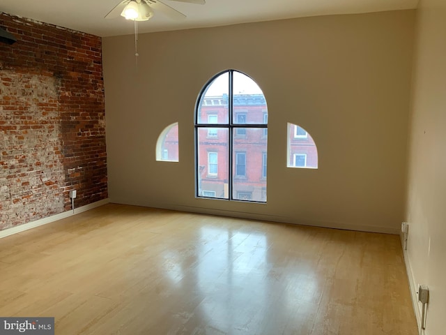 1921 W Diamond St, Philadelphia, PA 19121 - unfurnished room with baseboards, brick wall, light wood finished floors, and ceiling fan