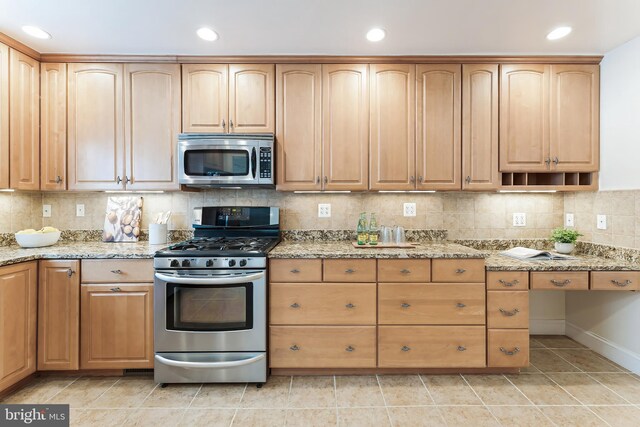 142 N French St, Alexandria, VA 22304 - kitchen featuring appliances with stainless steel finishes, recessed lighting, light stone counters, decorative backsplash, and baseboards