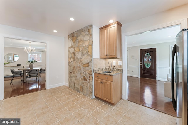 142 N French St, Alexandria, VA 22304 - kitchen with freestanding refrigerator, a sink, light stone counters, a chandelier, and recessed lighting