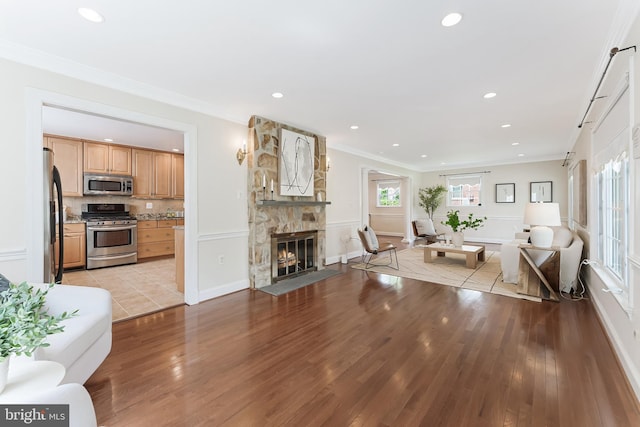 142 N French St, Alexandria, VA 22304 - living area featuring light wood-style floors, a fireplace, recessed lighting, baseboards, and crown molding