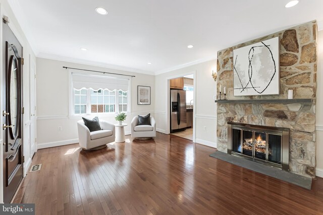 142 N French St, Alexandria, VA 22304 - living area with plenty of natural light, crown molding, wood finished floors, baseboards, and a stone fireplace