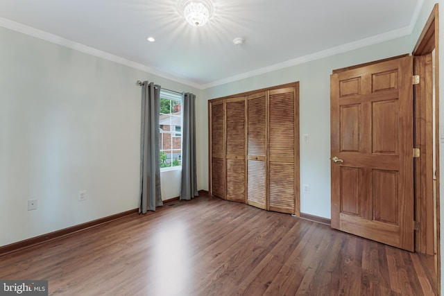 142 N French St, Alexandria, VA 22304 - unfurnished bedroom with wood finished floors, a closet, baseboards, crown molding, and a chandelier