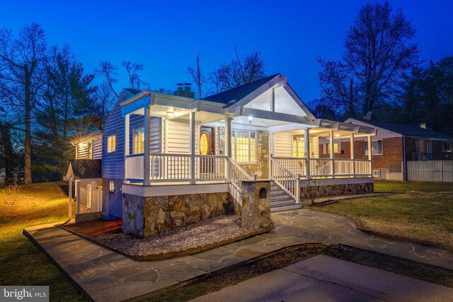 142 N French St, Alexandria, VA 22304 - view of front of property with covered porch, a lawn, a chimney, and stone siding