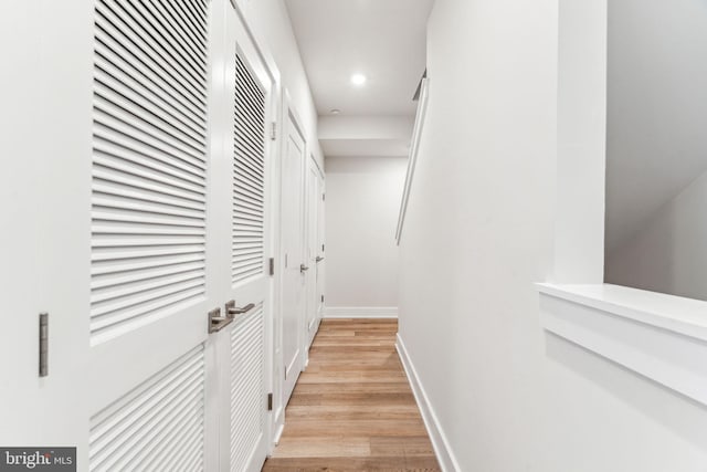 hall with baseboards, recessed lighting, and light wood-style floors