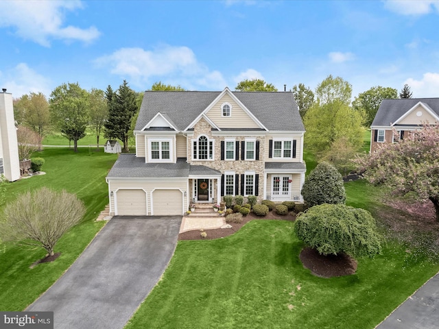 view of front of property with driveway, a garage, a front lawn, and stone siding
