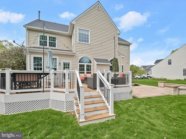 back of house with a lawn, a deck, and a shingled roof
