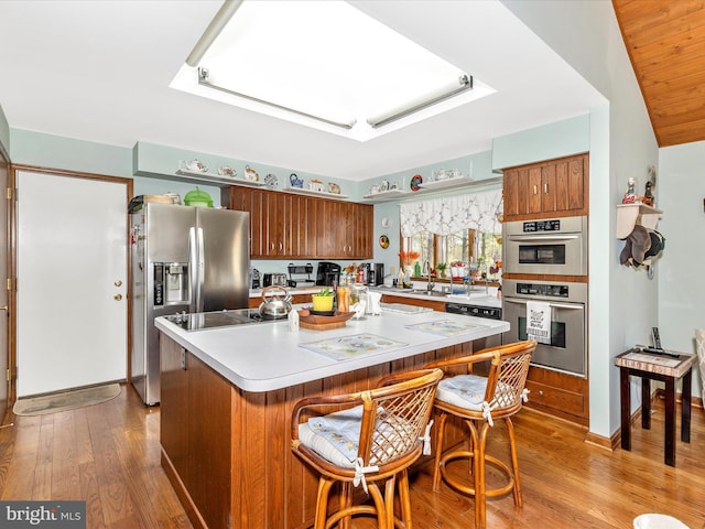 10334 Harp Rd, Walkersville, MD 21793 - kitchen featuring a skylight, brown cabinetry, and wood finished floors