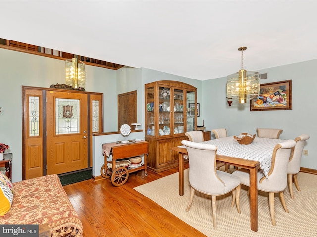 10334 Harp Rd, Walkersville, MD 21793 - dining space featuring visible vents, wood finished floors, and an inviting chandelier
