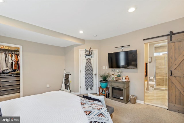 2205 Elsinore Ave, Baltimore, MD 21216 - carpeted bedroom with a barn door, recessed lighting, baseboards, connected bathroom, and a walk in closet