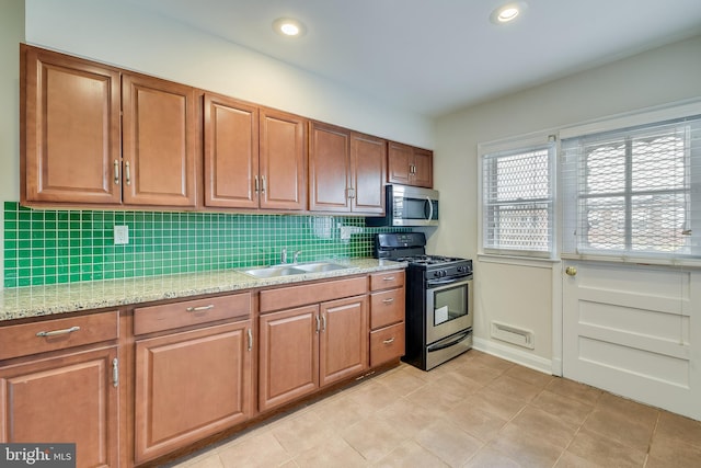 4720 Kimberleigh Rd, Baltimore, MD 21212 - kitchen with tasteful backsplash, a sink, stainless steel microwave, range with gas stovetop, and brown cabinetry