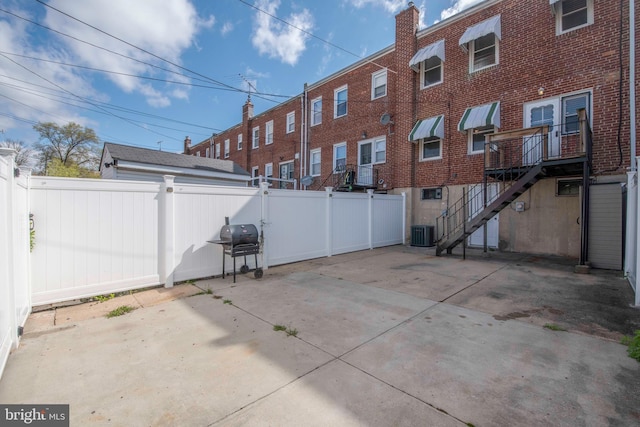 4720 Kimberleigh Rd, Baltimore, MD 21212 - rear view of house with central AC, a chimney, a fenced backyard, a patio, and brick siding