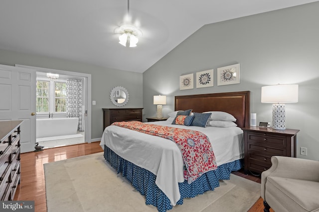 bedroom featuring wood finished floors, baseboards, and vaulted ceiling