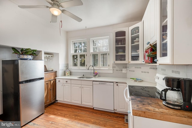 kitchen featuring white cabinetry, light wood-type flooring, white appliances, a sink, and a ceiling fan