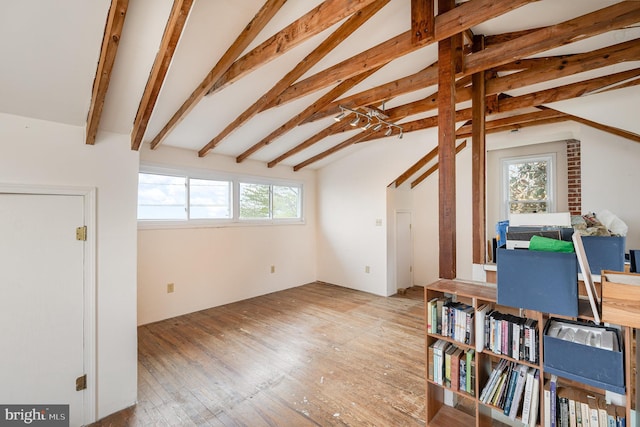interior space featuring lofted ceiling with beams and hardwood / wood-style flooring