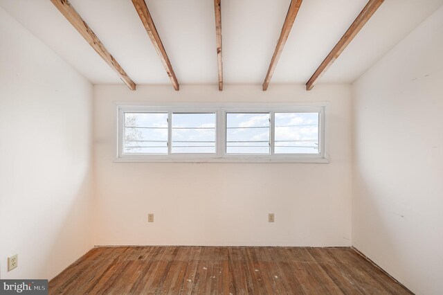 empty room with beamed ceiling and wood finished floors